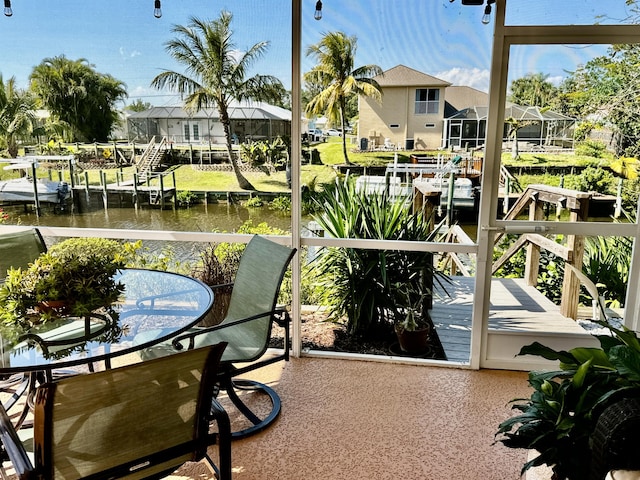 balcony with a dock, a water view, and a residential view