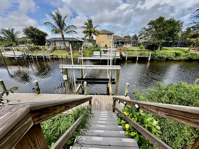 dock area featuring a water view, boat lift, and a residential view