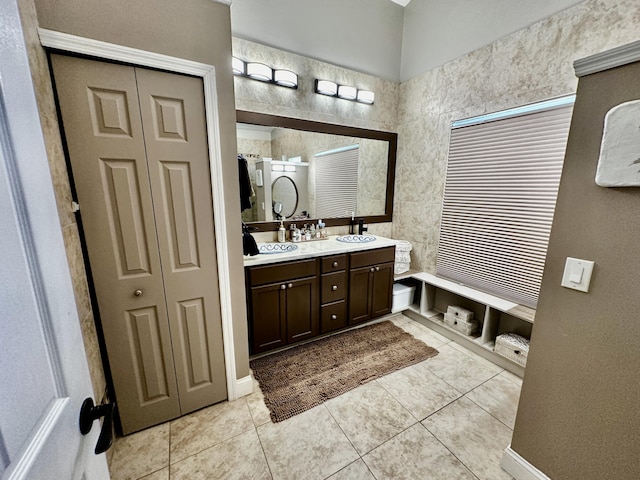 full bath with a sink, a shower, a closet, tile patterned floors, and double vanity