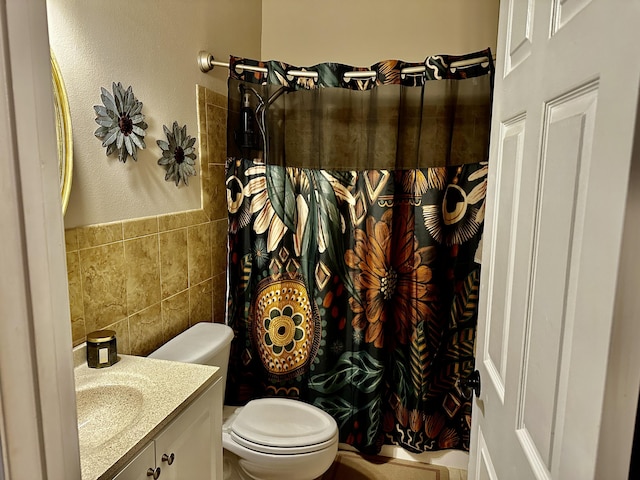 bathroom featuring toilet, a shower with curtain, tile walls, and vanity