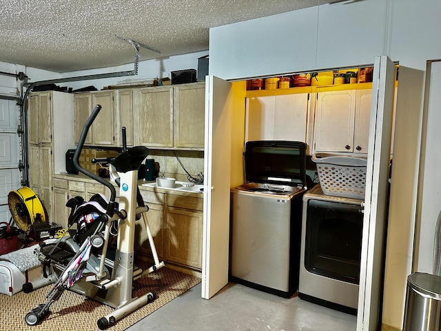 exercise area with a textured ceiling, washing machine and clothes dryer, and a garage