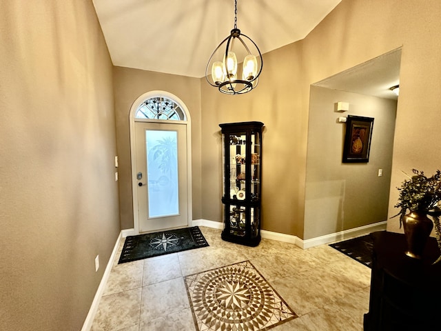 foyer with tile patterned flooring, baseboards, and an inviting chandelier