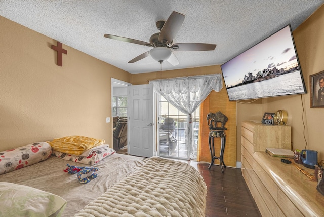 bedroom featuring dark hardwood / wood-style flooring, a textured ceiling, ceiling fan, and access to exterior