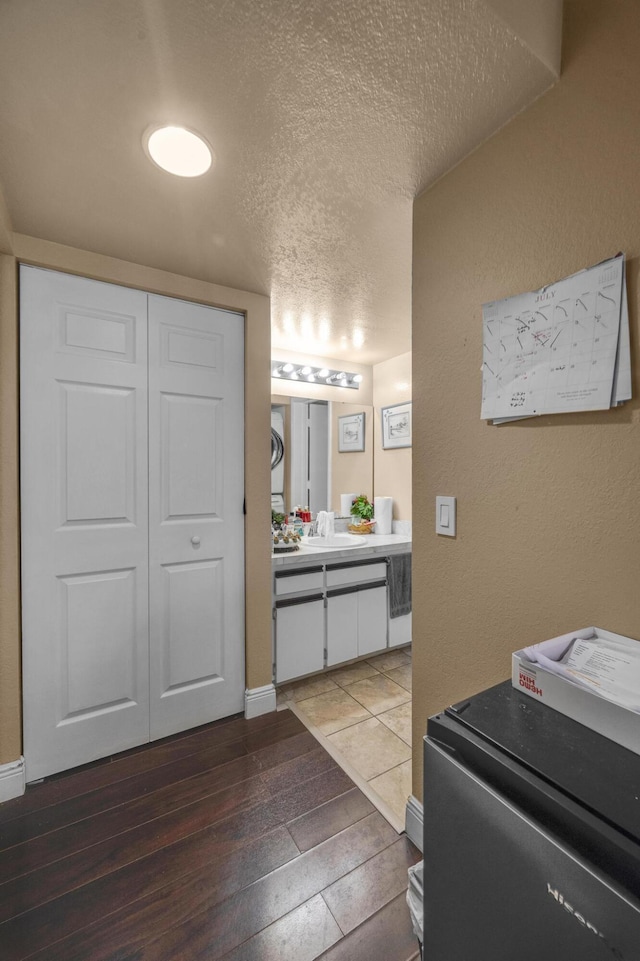 bathroom with vanity, wood-type flooring, and a textured ceiling