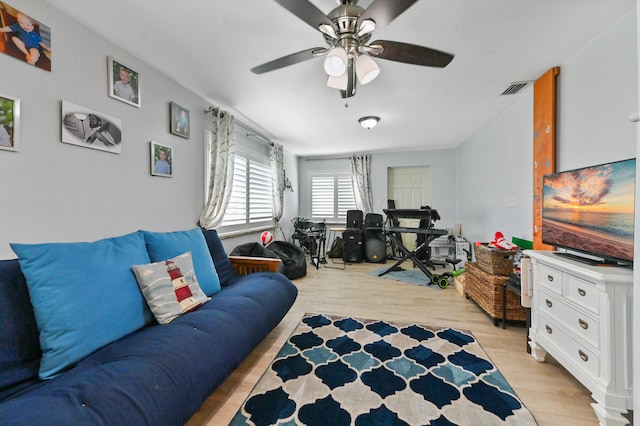 living room with ceiling fan and light hardwood / wood-style flooring