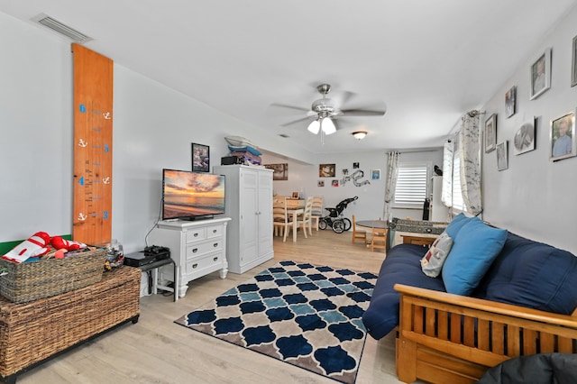 living room featuring ceiling fan and light wood-type flooring