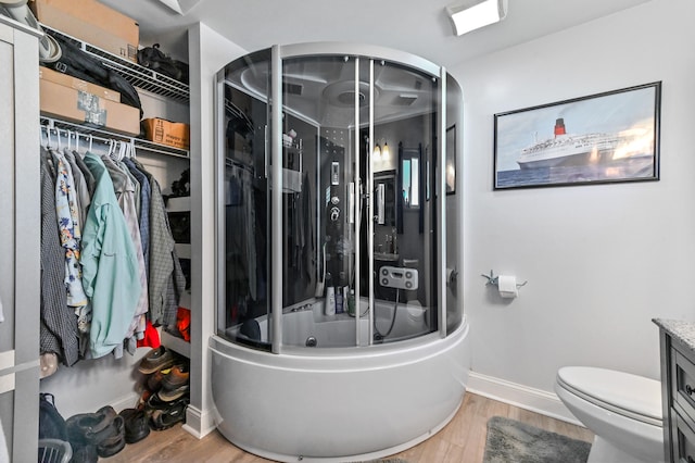 full bathroom featuring toilet, vanity, wood-type flooring, and enclosed tub / shower combo