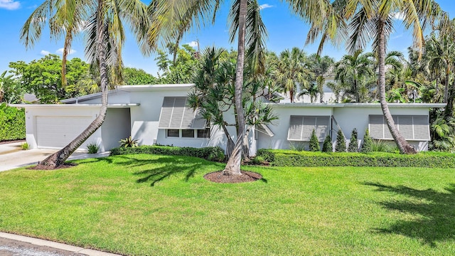 single story home featuring a garage and a front lawn