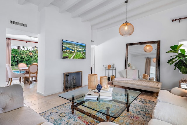 living room with beam ceiling and light tile patterned floors