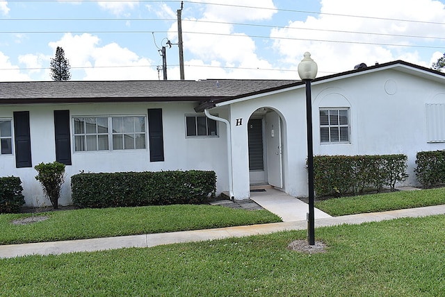 single story home featuring a front lawn