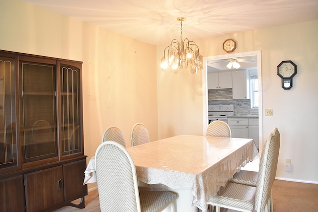 carpeted dining room with ceiling fan with notable chandelier