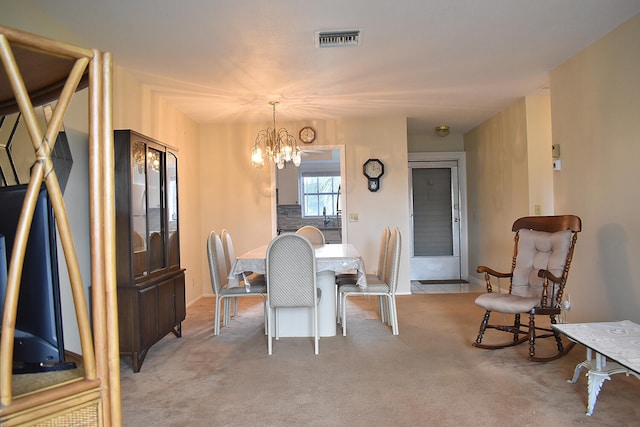 carpeted dining area with a chandelier