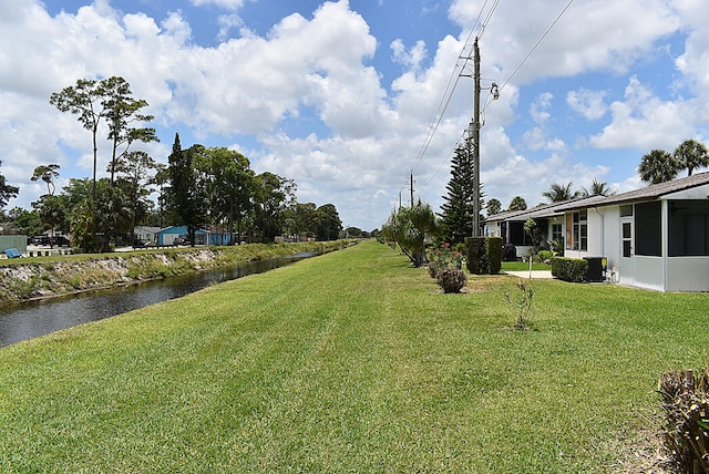 view of yard featuring cooling unit and a water view