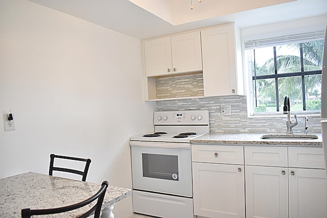 kitchen featuring white range with electric stovetop, white cabinetry, sink, and light stone countertops