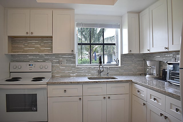 kitchen with white cabinetry, sink, light stone counters, tasteful backsplash, and white electric range