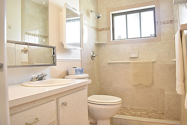 bathroom featuring vanity, toilet, and a tile shower