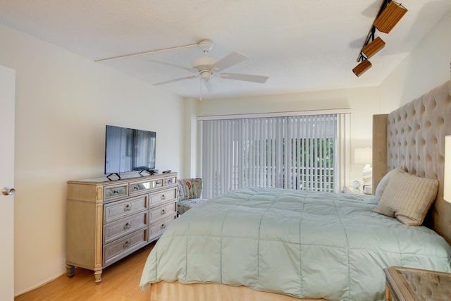 bedroom with a textured ceiling, ceiling fan, and light hardwood / wood-style flooring