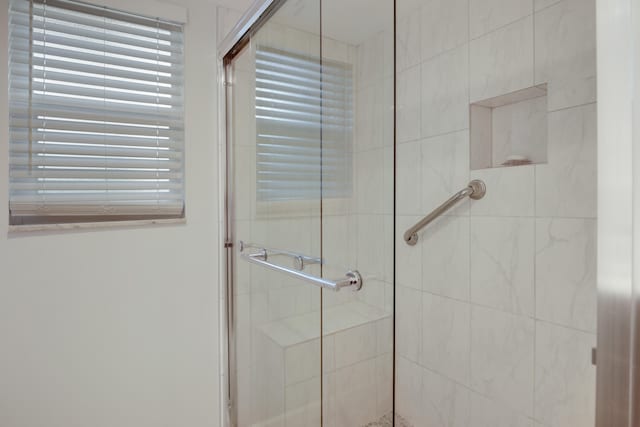 bathroom featuring a shower with door