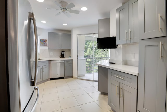 kitchen featuring gray cabinets, light tile patterned flooring, ceiling fan, and stainless steel appliances