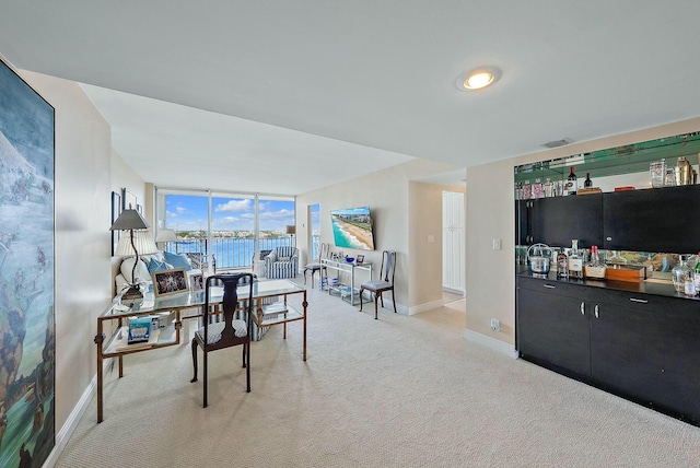 dining area featuring baseboards, expansive windows, visible vents, and light colored carpet