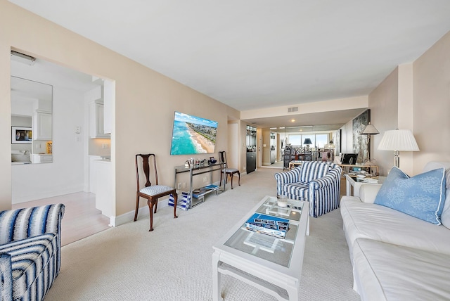 living room featuring light colored carpet, visible vents, and baseboards