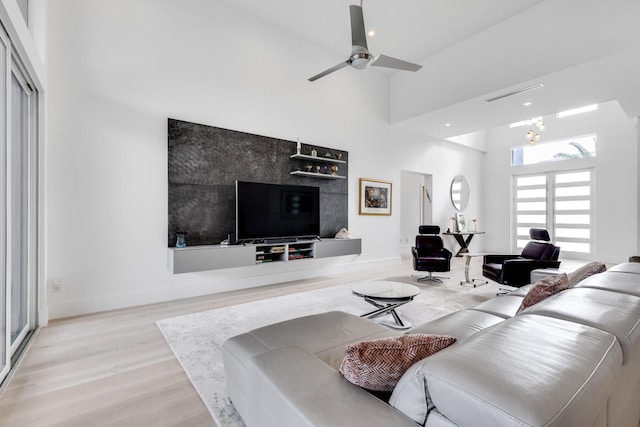 living room with high vaulted ceiling, light wood-type flooring, and ceiling fan