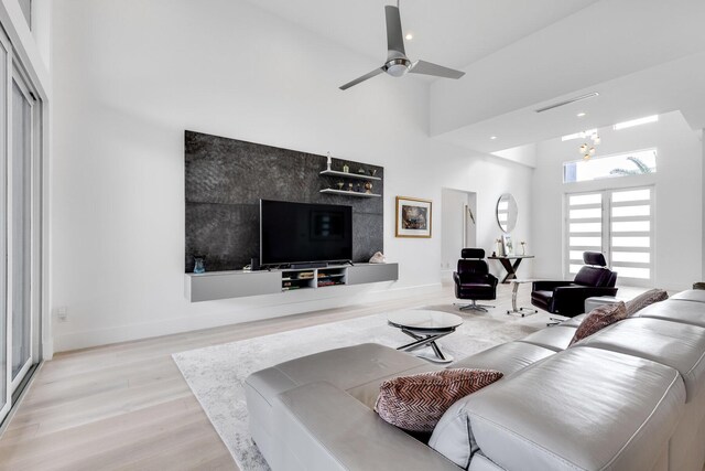 kitchen featuring wall chimney exhaust hood, white cabinetry, a kitchen island with sink, and appliances with stainless steel finishes