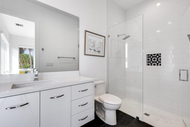 bedroom with ensuite bathroom, light wood-type flooring, and ceiling fan