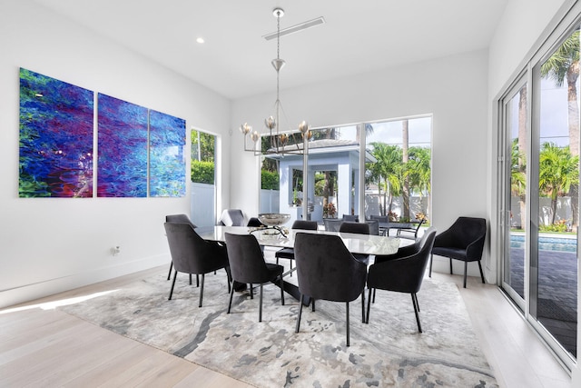 dining room with an inviting chandelier and light hardwood / wood-style flooring