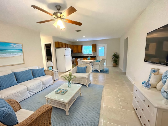 tiled living room with ceiling fan and sink