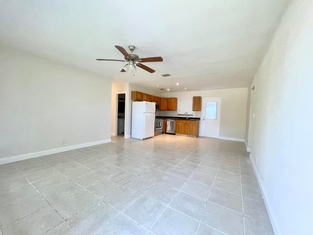 unfurnished living room featuring ceiling fan and sink