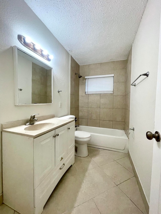 full bathroom with vanity, tile patterned floors, tiled shower / bath, toilet, and a textured ceiling