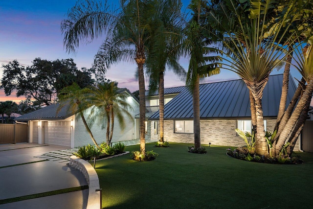 view of front of house featuring a garage and a yard