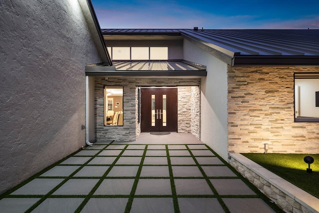 exterior entry at dusk with french doors and a patio area