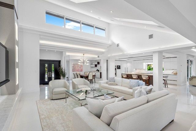 living room with a towering ceiling and an inviting chandelier