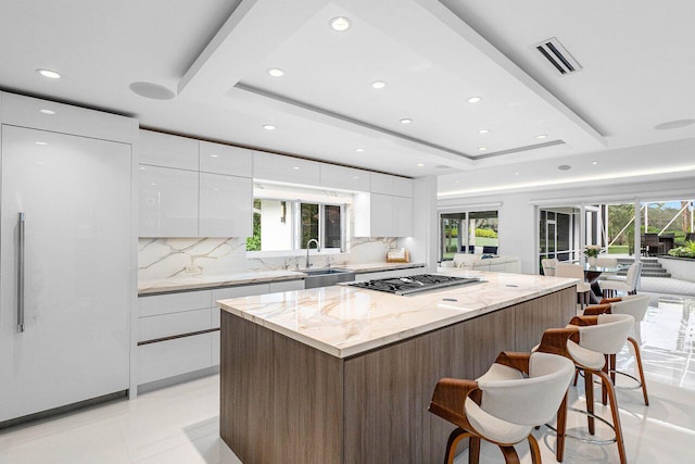 kitchen featuring a wealth of natural light, white cabinetry, and sink