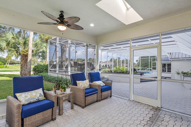 sunroom featuring vaulted ceiling with skylight and ceiling fan