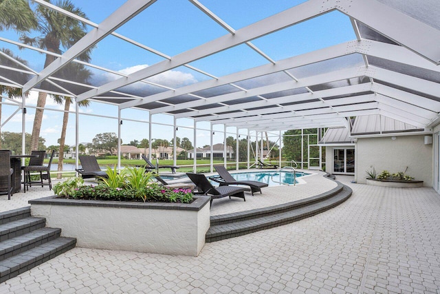 view of pool with glass enclosure and a patio