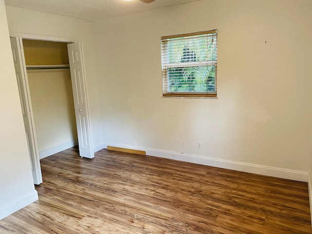 unfurnished bedroom with wood-type flooring and a closet