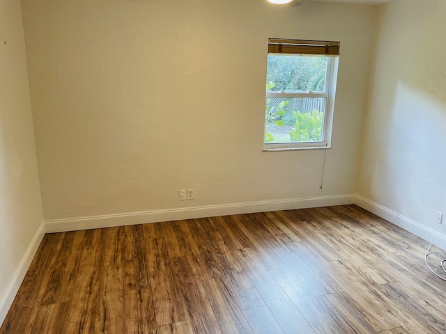 unfurnished room with hardwood / wood-style flooring