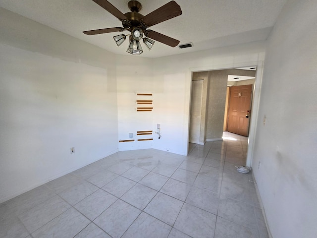 tiled spare room featuring ceiling fan and a textured ceiling