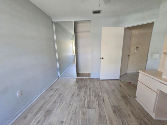 unfurnished bedroom with a closet and light wood-type flooring