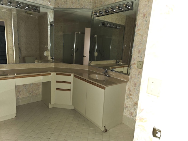 bathroom with toilet, vanity, tile patterned floors, and a shower with shower door