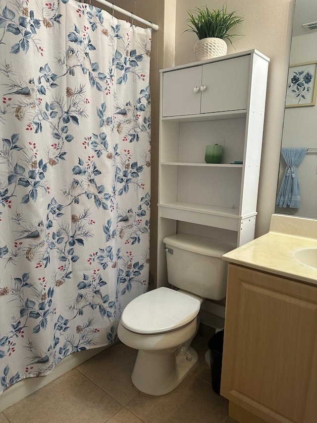 bathroom featuring tile patterned flooring, vanity, toilet, and curtained shower