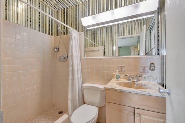 bathroom featuring a shower with shower curtain, vanity, toilet, and tile walls