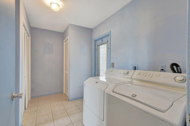 clothes washing area with light tile patterned floors and washing machine and clothes dryer