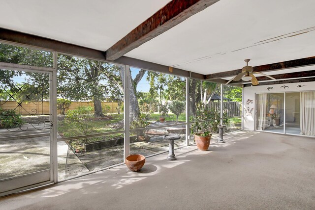 unfurnished sunroom with ceiling fan and beamed ceiling