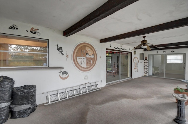 interior space with beam ceiling, ceiling fan, and carpet