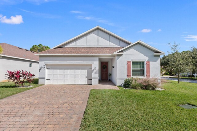 single story home with a garage and a front lawn