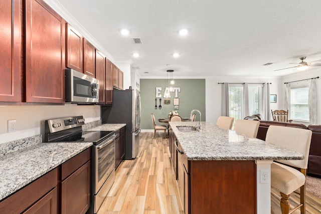 kitchen featuring pendant lighting, a breakfast bar, sink, and appliances with stainless steel finishes